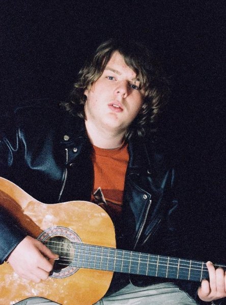 Andrew with guitar and leather jacket. regular lens