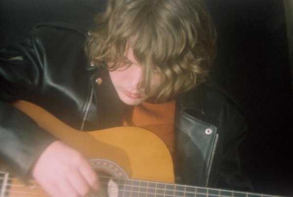 Andrew with guitar and leather jacket. soft focus lens